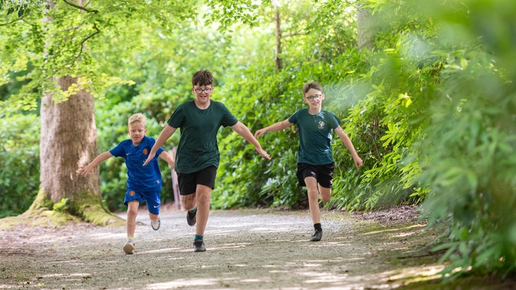 Chidren running on a path next to the lake at Llanerchaeron, Ceredigion